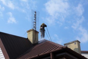 SoftWashing Company - a man soft washing a roof